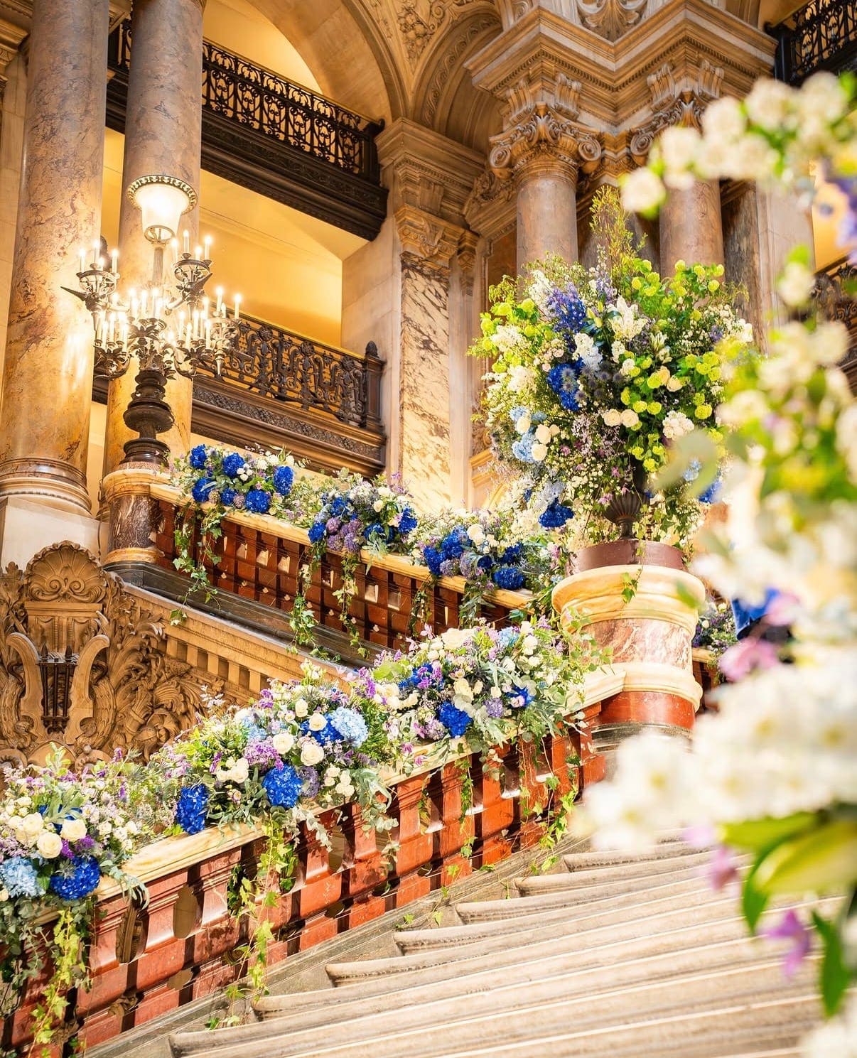 Escalier du Palais Garnier habillé de compositions florales bleues et blanches