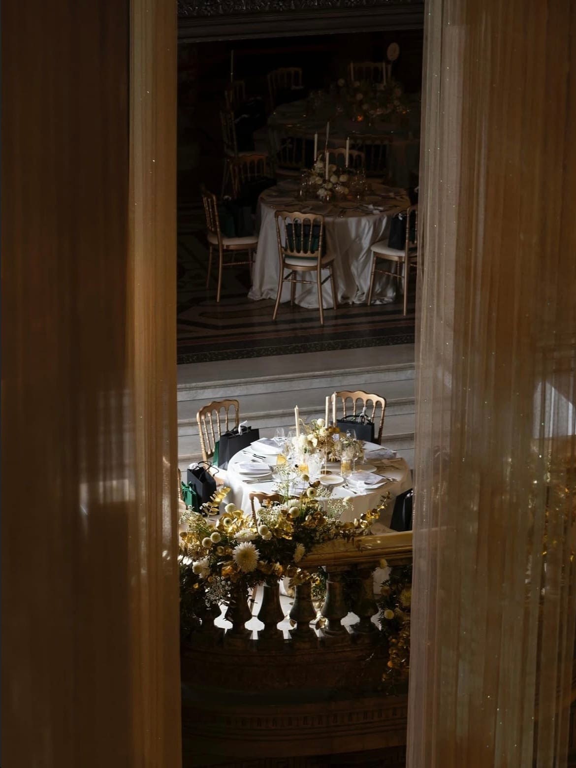 Tables du dîner de gala aperçues derrière un rideau